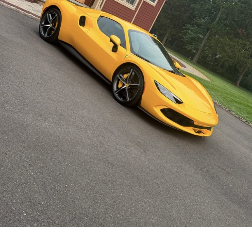 Yellow Ferrari parked in a residential driveway